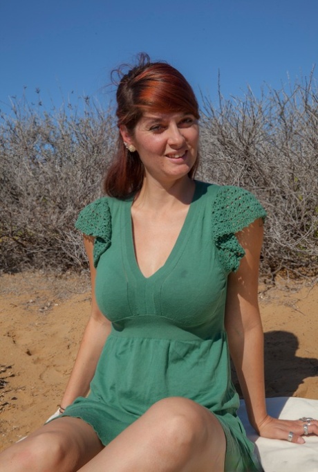 Горячая рыжеволосая любительница раздевается, чтобы выставить напоказ свою красивую попку на одеяле снаружи картинка 1