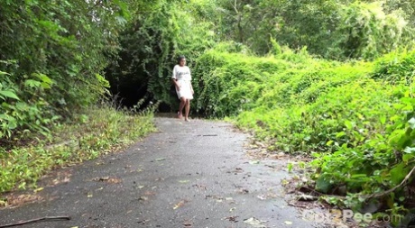 Одинокая женщина Хлоя Ламур мочится на мощеную дорожку в сандалиях картинка 1