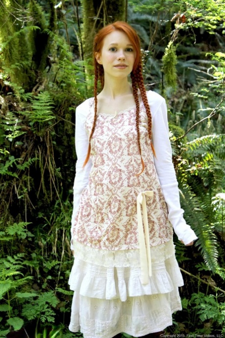 Молодая рыжеволосая девушка с косичками и в сапогах занимается йогой обнаженной в лесу картинка 1