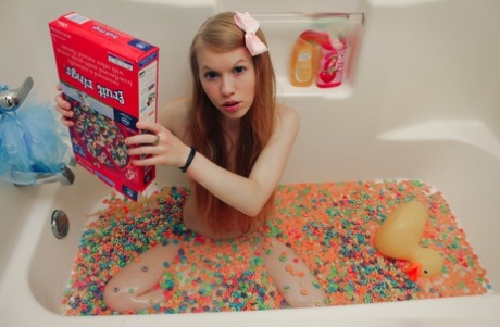Молодо выглядящая девушка Долли Литтл высыпает коробку хлопьев в воду для ванны картинка 2