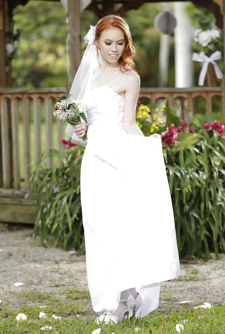Рыжеволосая молоденькая красотка Долли Литтл снимает свадебное платье на открытом воздухе картинка 1