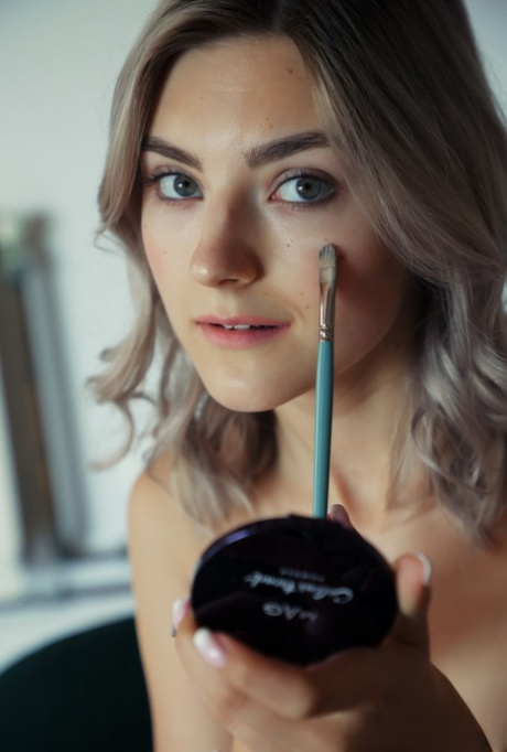 Молодая платиновая блондинка Ева Элфи делает макияж во время выступления обнаженной модели картинка 2