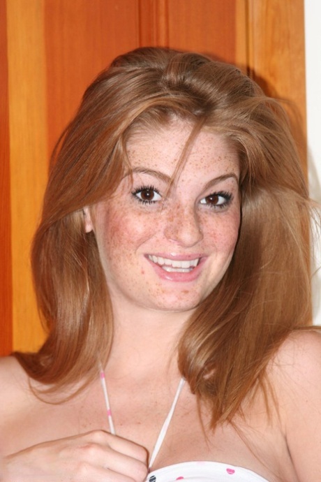 Рыжая с веснушками обнажает свои увеличенные сиськи, прежде чем потрогать пальцами свою розовую киску картинка 2