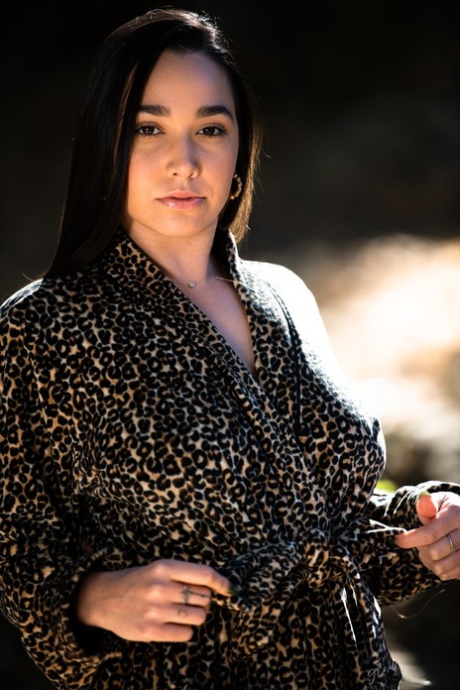 Темноволосая девушка демонстрирует свои натуральные сиськи и сексуальную попку, раздеваясь картинка 1