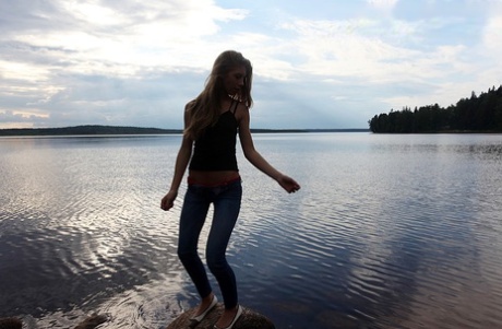 Девушка по соседству Меган показывает свои сиськи, сидя на камне в озере картинка 3