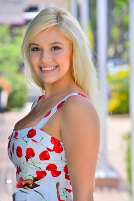 Симпатичная блондинка приподнимает короткое платье, обнажая верхнюю юбку, и теребит пальцами лысую киску снаружи картинка 4