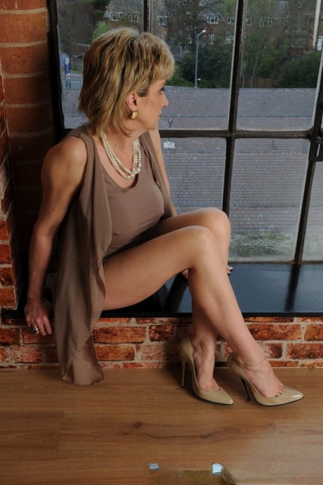 Пожилая британская блондинка Соня показывает свои голые ноги в платье и на каблуках картинка 11