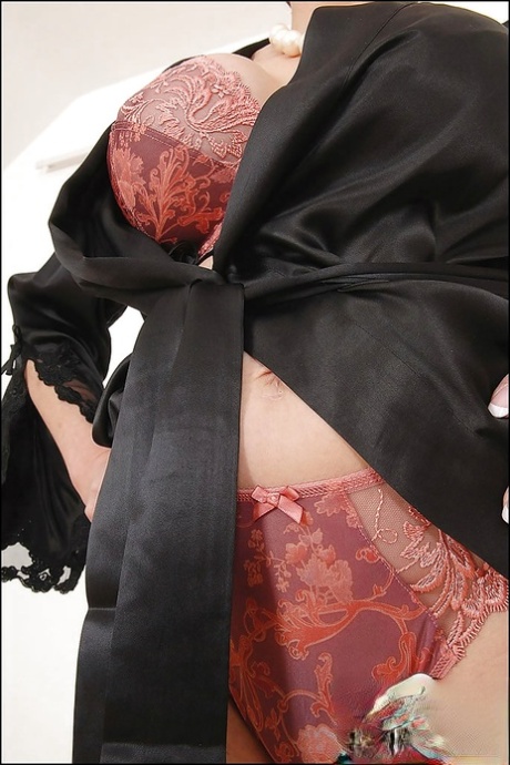 Длинноногая зрелая леди на высоких каблуках позирует в шелковой ночной рубашке и нижнем белье картинка 7