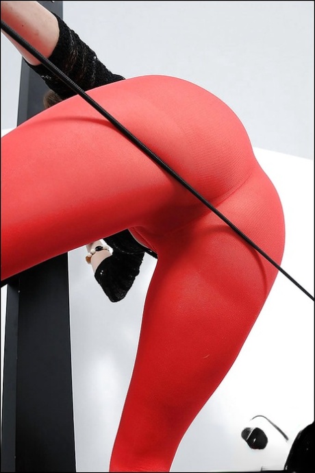 Сексуальная зрелая красотка с большими сиськами и горячей попкой позирует в красных колготках картинка 10