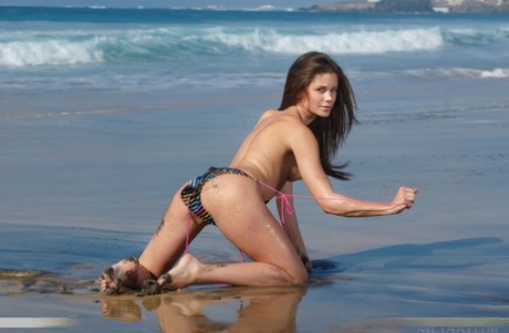 Одетая в бикини красотка Caprice A раздевается, чтобы показать киску крупным планом на пляже картинка 10