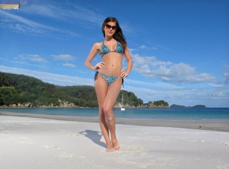 Сексуальная брюнетка Каприс снимает бикини, чтобы выставить напоказ красивые сиськи и раздвинутые ноги на пляже картинка 1