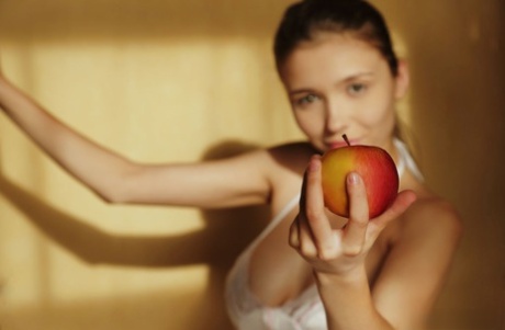 Красивая девушка-подросток показывает свои большие сиськи и лысую пизду, поедая фрукты картинка 1