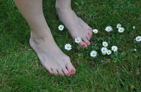 Британка Пиаже Турна лижет и сосет собственные пальцы ног на лужайке картинка 1