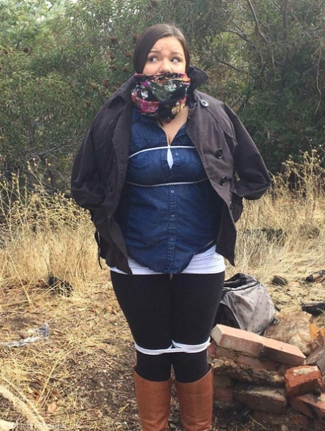 Полностью одетый толстяк расколот, с кляпом во рту и связанный веревкой в заросшем кустарником лесу картинка 3