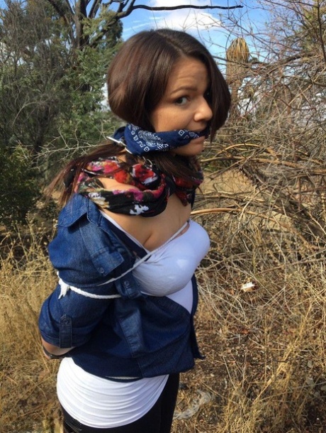 Полностью одетый толстяк расколот, с кляпом во рту и связанный веревкой в заросшем кустарником лесу картинка 12