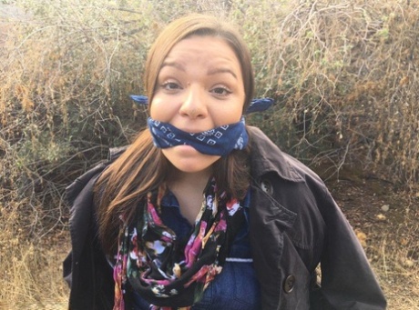 Полностью одетый толстяк расколот, с кляпом во рту и связанный веревкой в заросшем кустарником лесу картинка 1