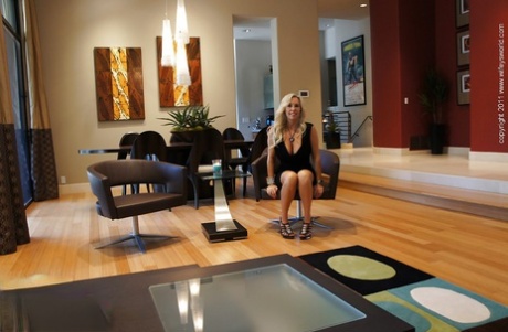 Великолепная блондинка на высоких каблуках обнажает свои большие сиськи и киску картинка 1