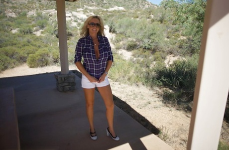 Улыбчивая зрелая блондинка в солнцезащитных очках сверкает своими великолепными сиськами на открытом воздухе картинка 13