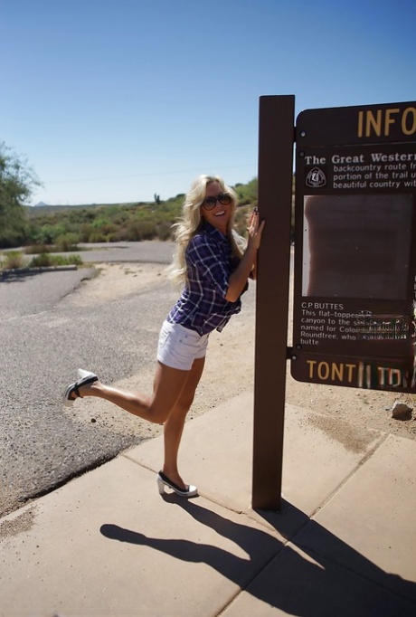 Улыбчивая зрелая блондинка в солнцезащитных очках сверкает своими великолепными сиськами на открытом воздухе картинка 3